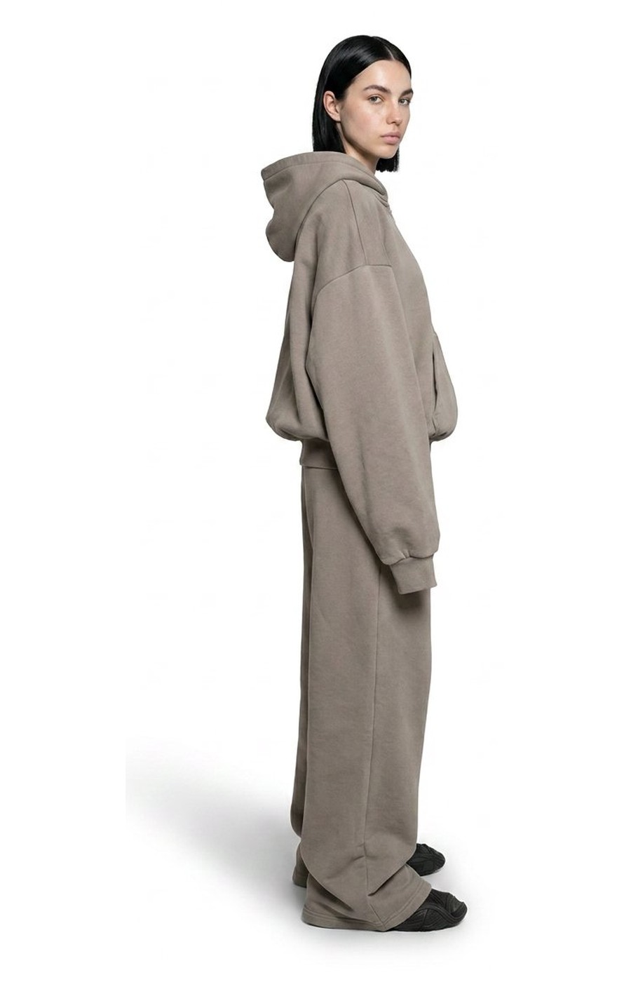 Model wearing Ghost 44 Factory grey hoodie and joggers, side profile