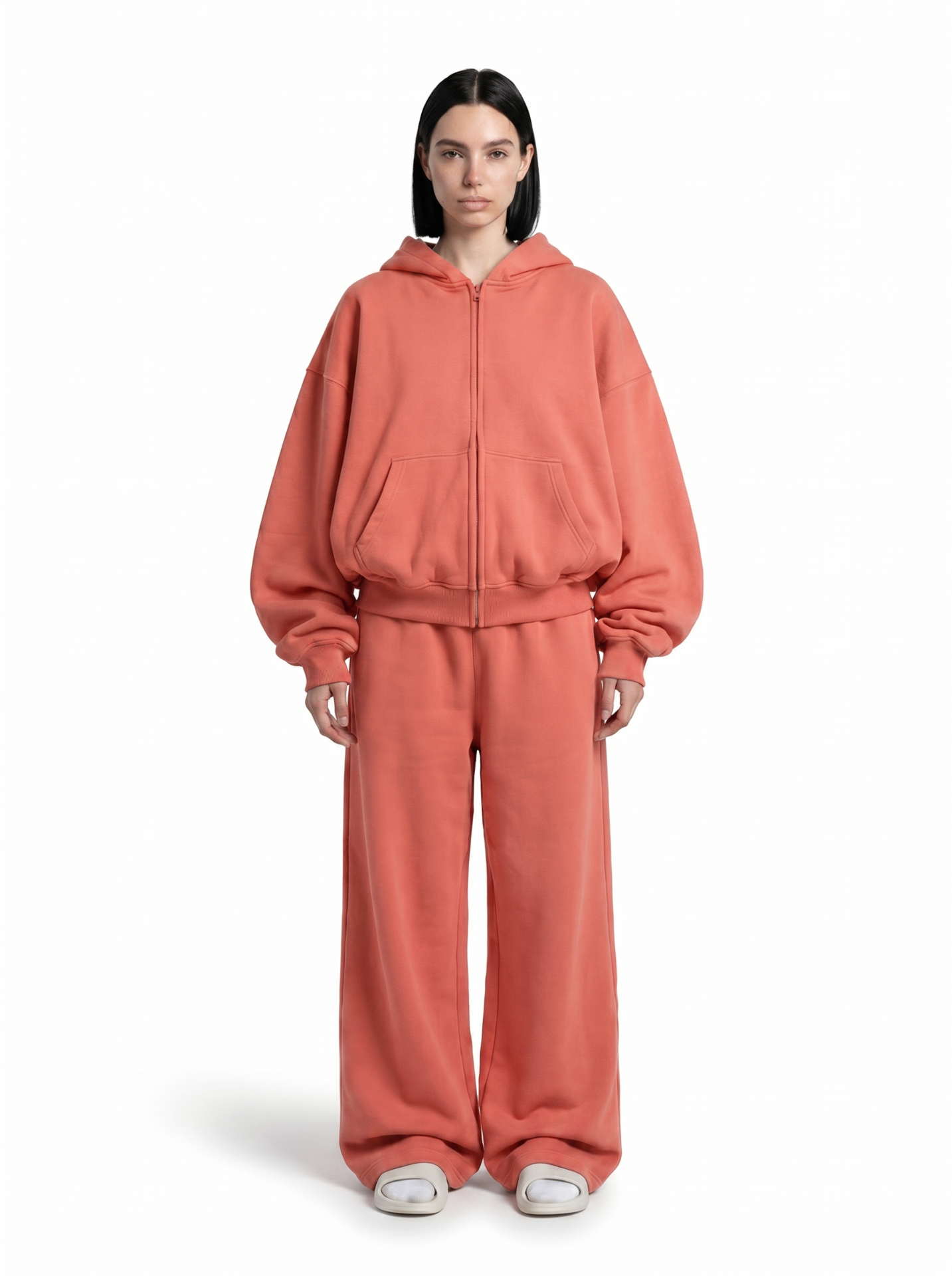 Model wearing a Ghost 44 Factory coral zip hoodie and wide-leg joggers