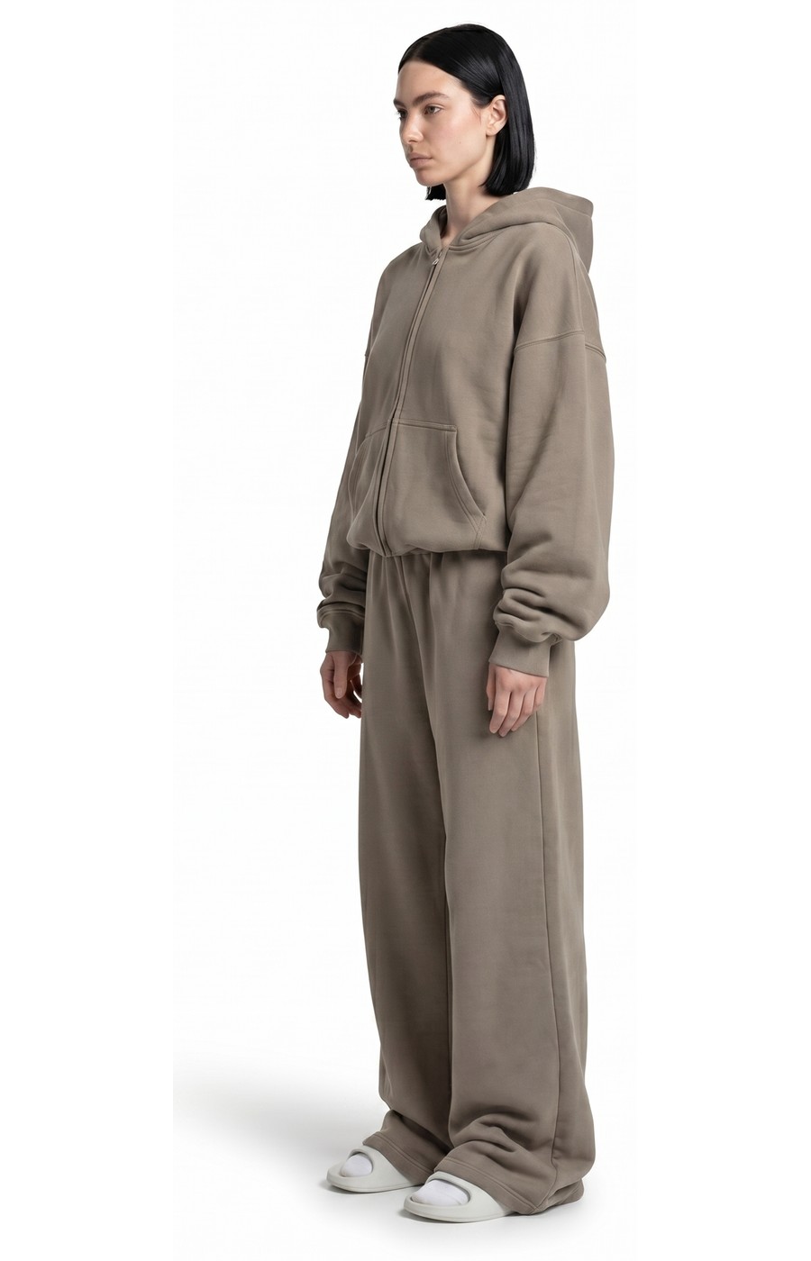Model wearing Ghost 44 Factory taupe zip hoodie and joggers, side profile